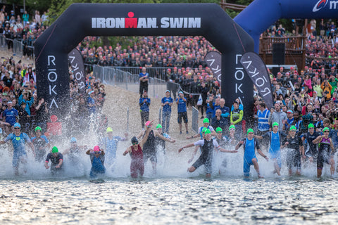 A diverse group of endurance athletes participating in an Ironman Triathlon, equipped with innovative hydration gear and high-performance apparel.